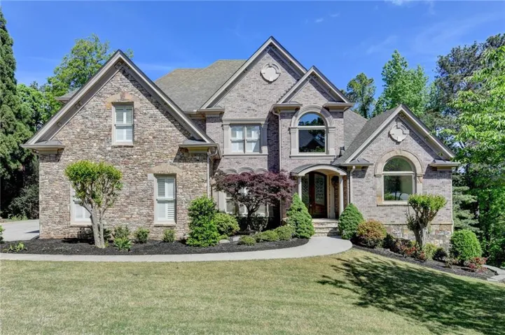 Stone and brick exterior with multiple gables and arched windows