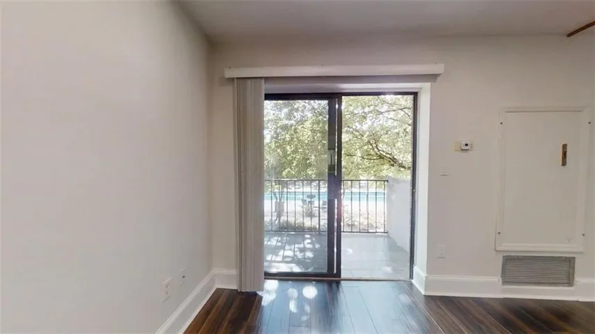 Dark wood-finish flooring with white baseboards throughout