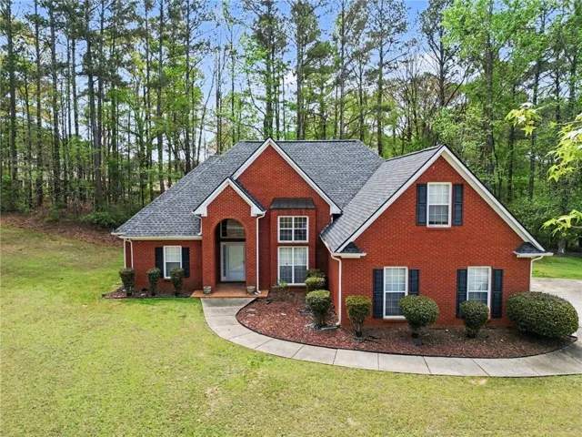 Red brick exterior with a dark shingle roof, arched entryway, and multiple gables