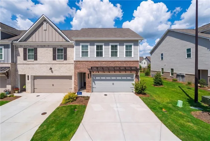 Brick and siding exterior with shutters, two single-car garages, and concrete driveways