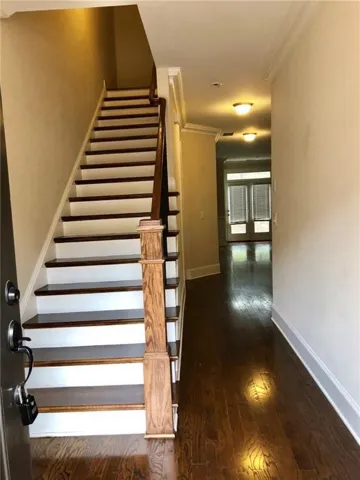 Inviting entryway featuring dark wood-finish flooring extending into the hallway