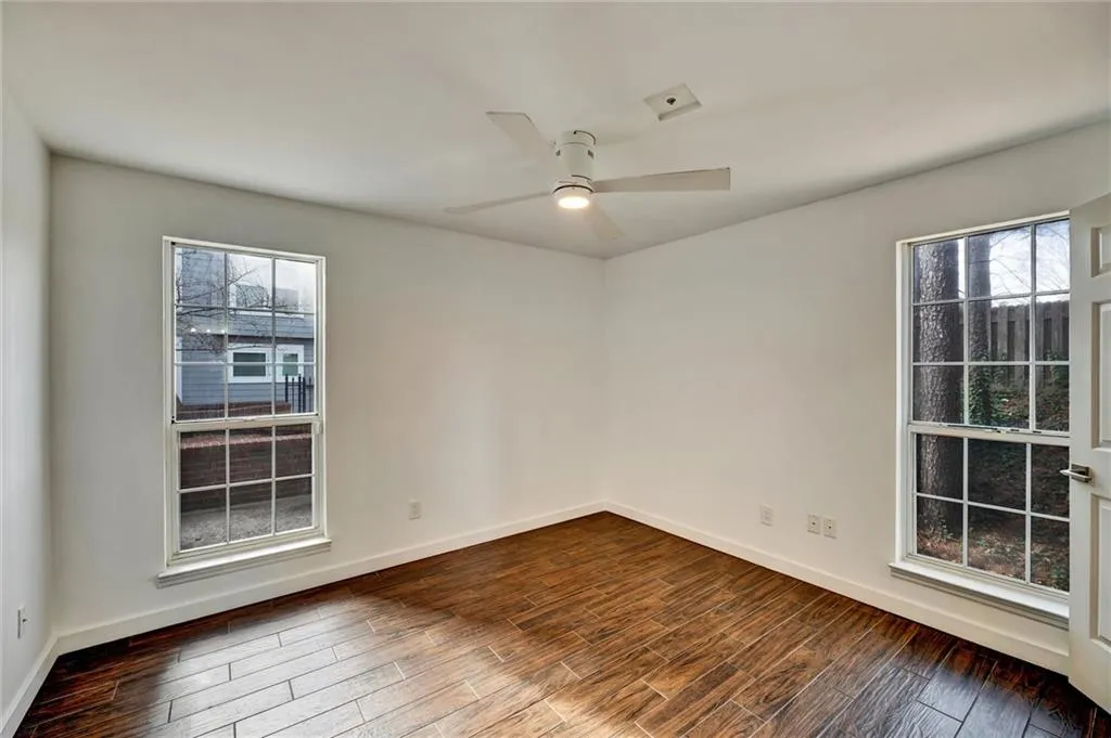 Empty room featuring dark wood-type flooring and baseboards