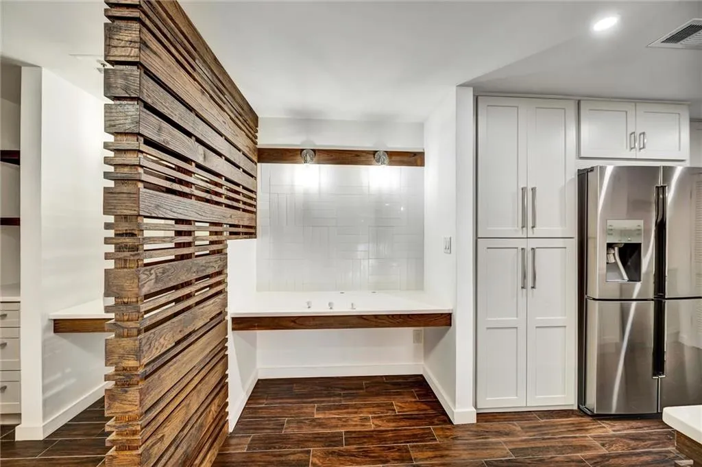 Kitchen featuring stainless steel fridge with ice dispenser and wood tiled floors