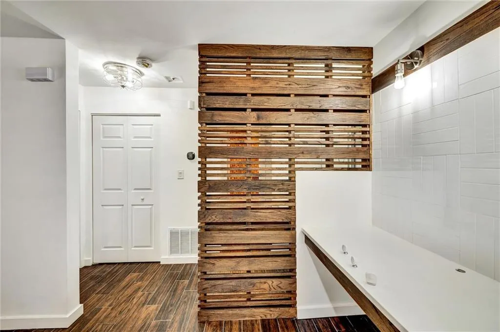 Full bathroom featuring dark wood-type flooring and baseboards