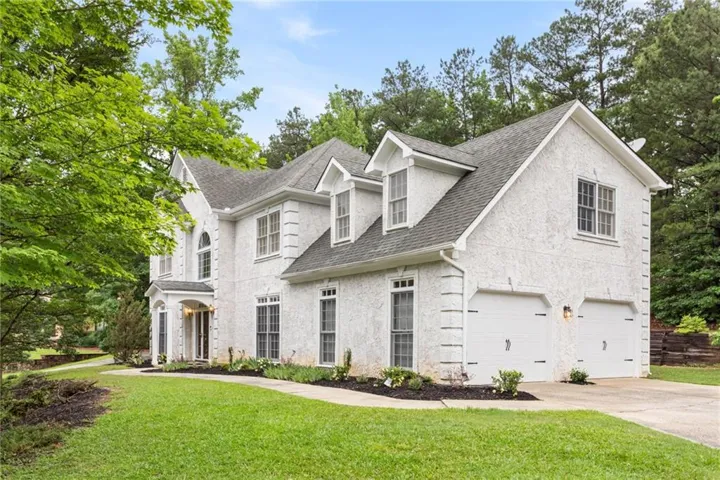 Stucco exterior with multiple dormer windows and an arched entry