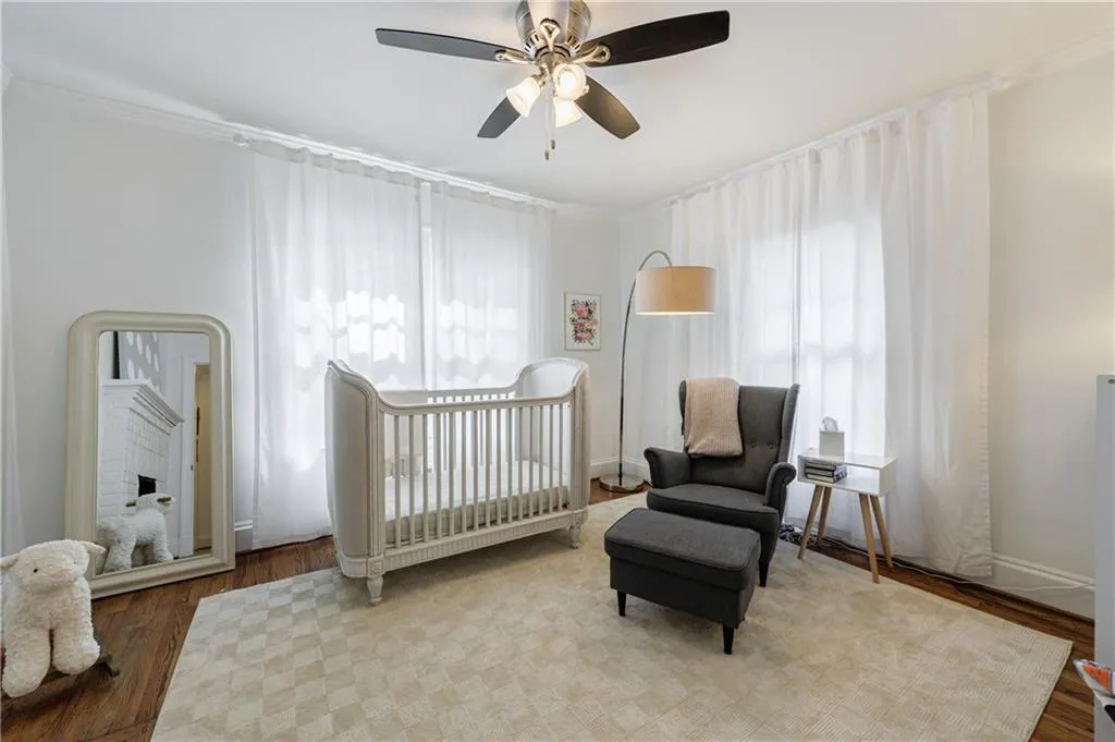 Bedroom with wood finished floors, ornamental molding, multiple windows, a ceiling fan, and baseboards