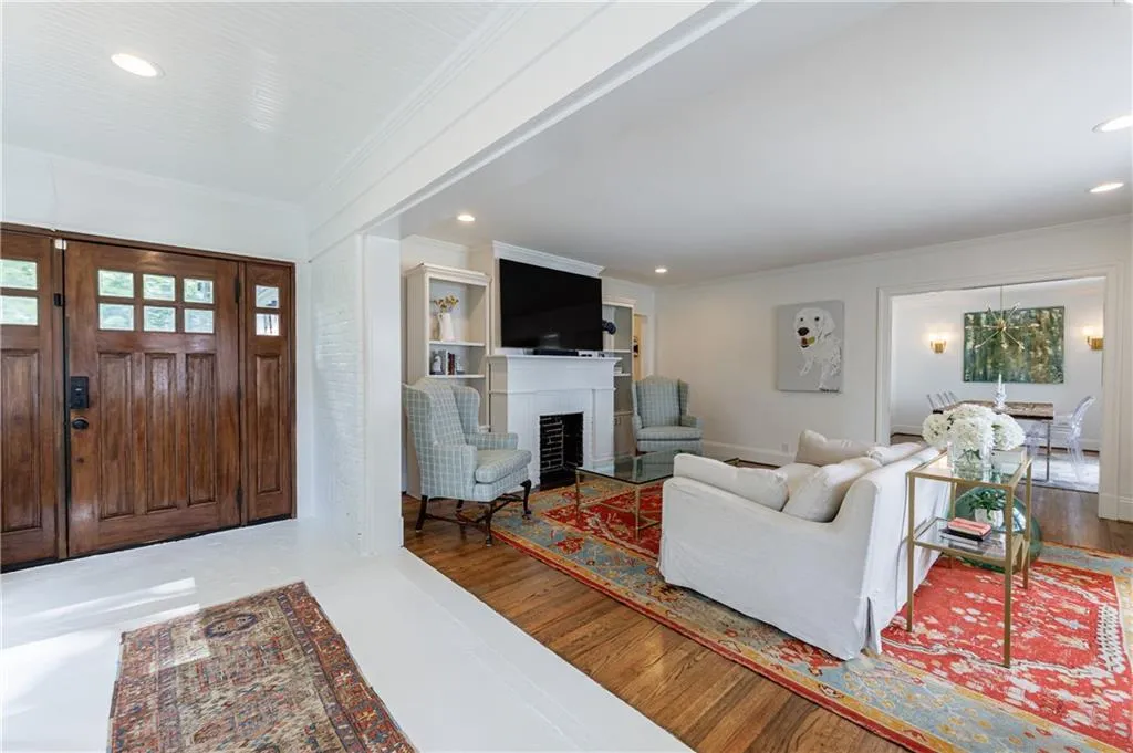 Living area featuring ornamental molding, recessed lighting, and a fireplace with flush hearth