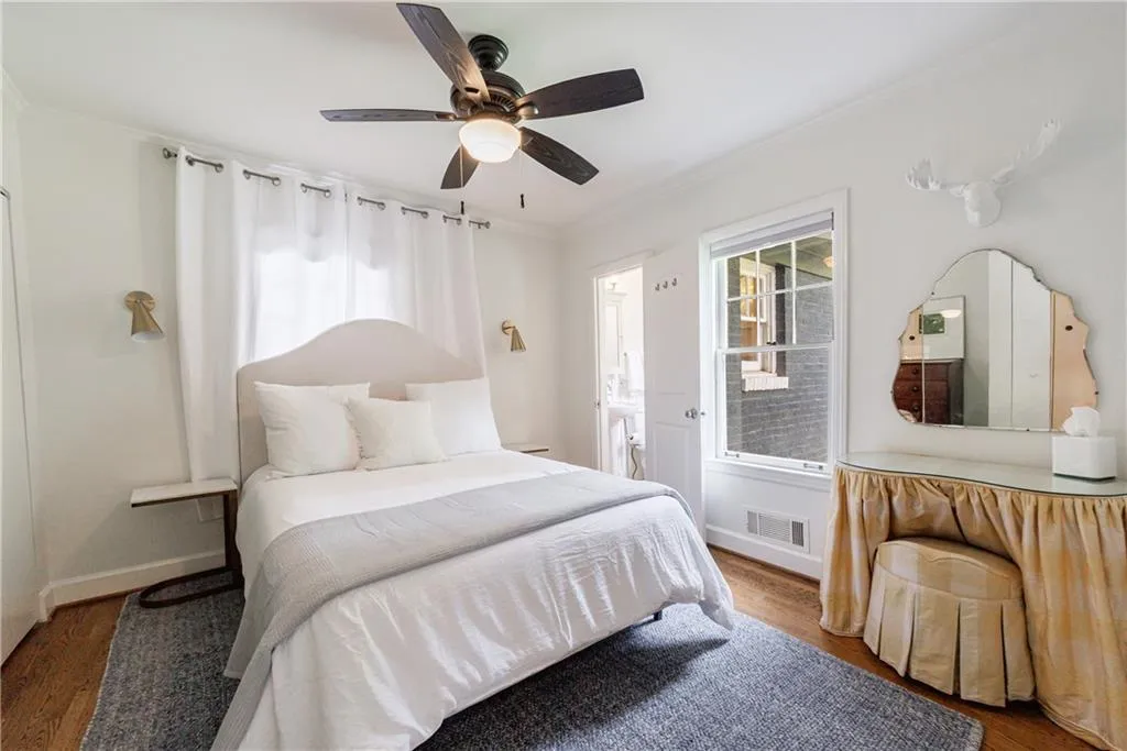 Bedroom featuring wood finished floors, ornamental molding, baseboards, and a ceiling fan