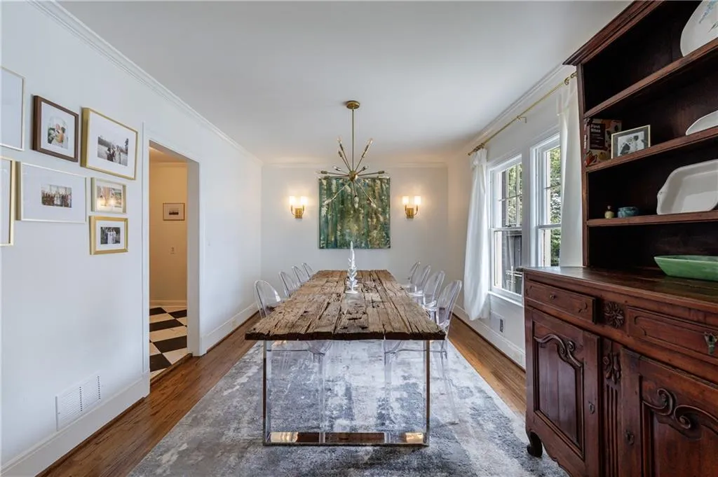 Dining room featuring wood finished floors, crown molding, a chandelier, and baseboards