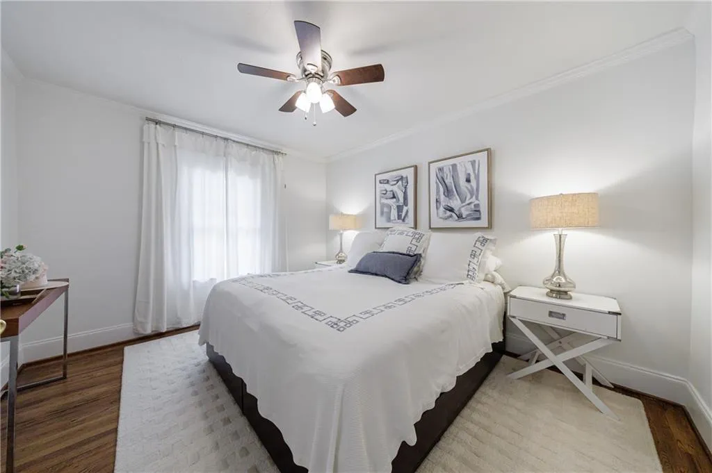 Bedroom with crown molding, baseboards, wood finished floors, and ceiling fan
