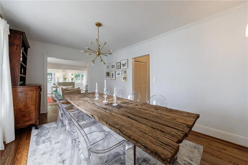 Dining space with a chandelier, ornamental molding, dark wood-style flooring, and baseboards