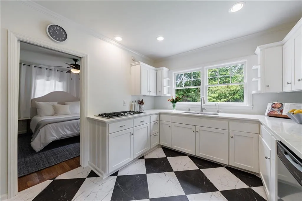 Kitchen with open shelves, appliances with stainless steel finishes, ornamental molding, a sink, and white cabinetry