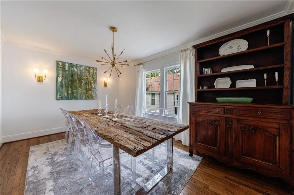 Dining space with a chandelier, crown molding, wood finished floors, and baseboards