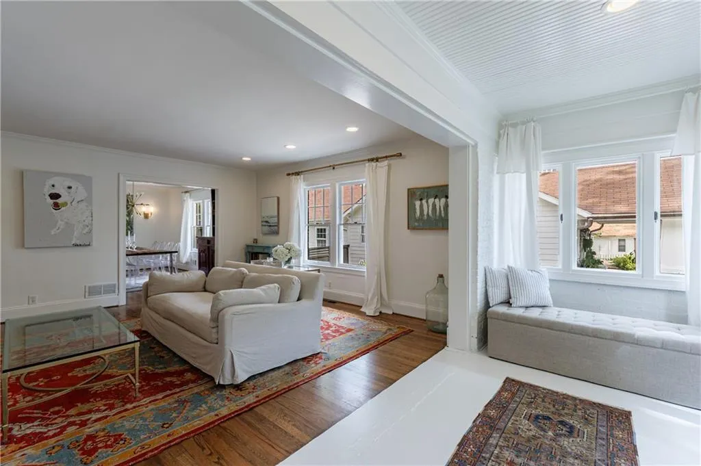 Living area featuring recessed lighting, wood finished floors, ornamental molding, and baseboards