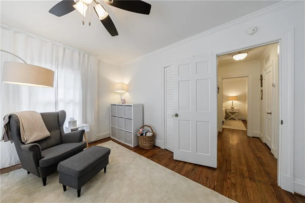 Sitting room with ornamental molding, wood finished floors, ceiling fan, and baseboards
