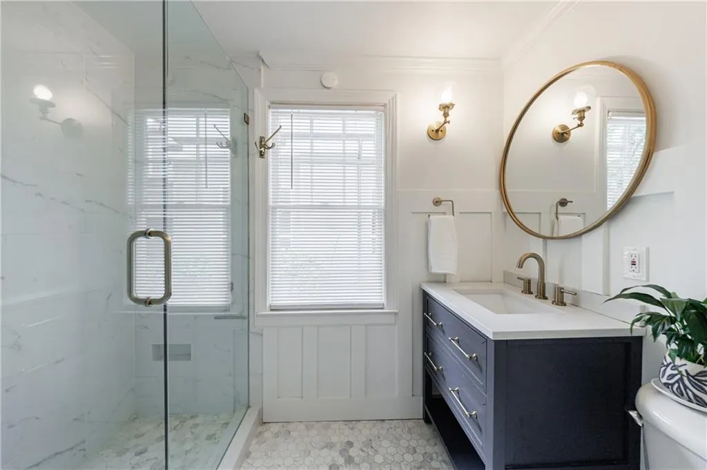 Full bathroom with vanity, a marble finish shower, crown molding, toilet, and a wainscoted wall