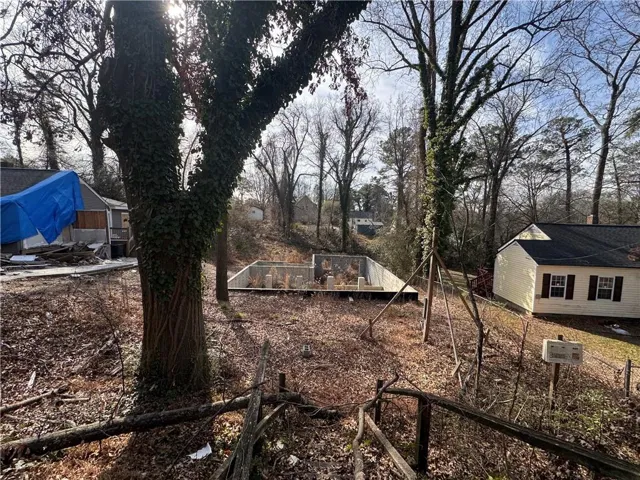 View of yard with a garden and view of wooded area