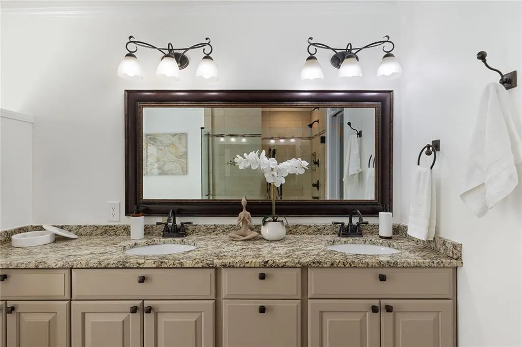 Full bath featuring a shower stall and double vanity
