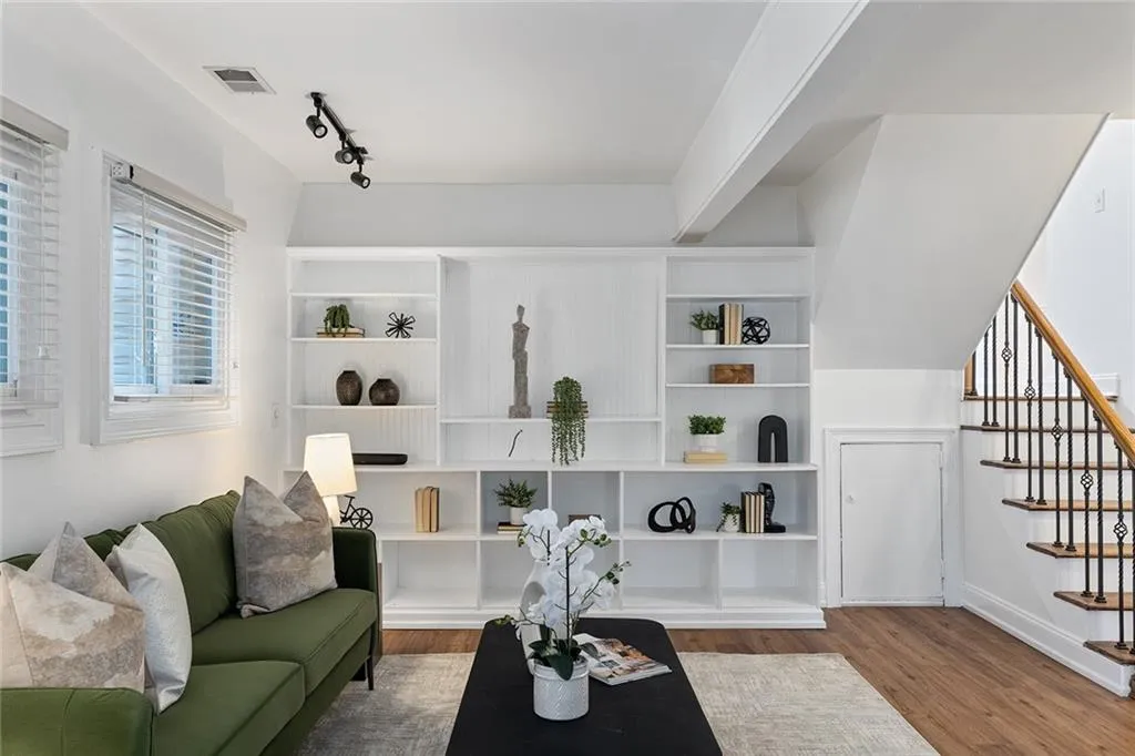 Living room with wood finished floors and track lighting