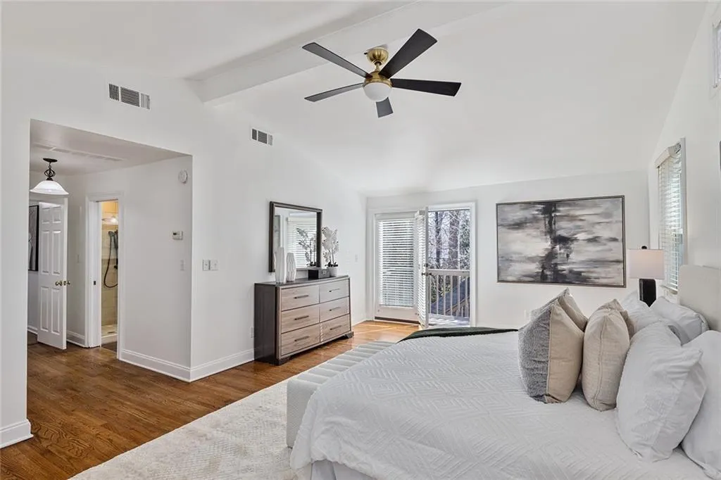 Bedroom featuring access to exterior, light wood-style flooring, beam ceiling, and ceiling fan