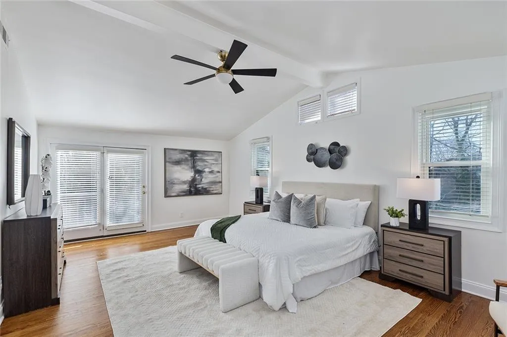 Bedroom with beam ceiling, ceiling fan, and dark wood-style floors