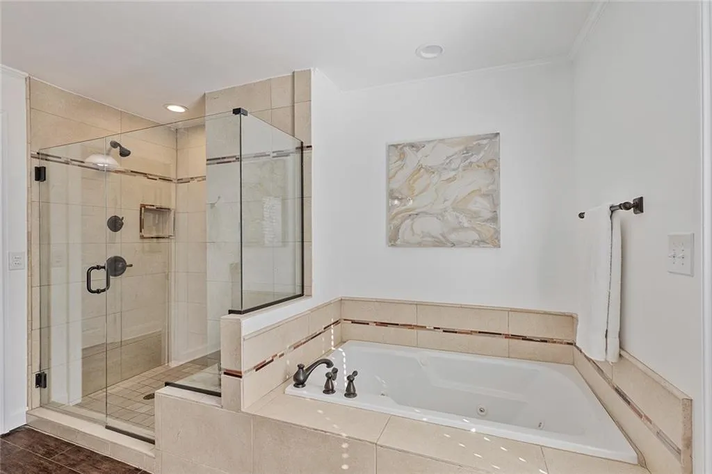 Full bath with a stall shower and a jetted tub