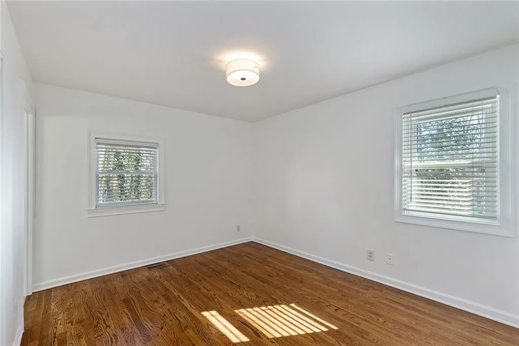 Unfurnished room featuring dark wood-style flooring and baseboards
