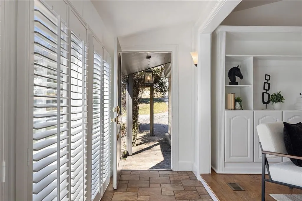 Foyer entrance with stone finish flooring and vaulted ceiling