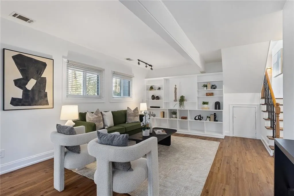 Living area with light wood finished floors, rail lighting, and beam ceiling