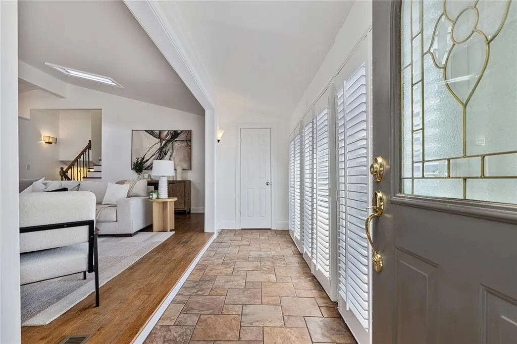 Foyer entrance with stone finish floors and vaulted ceiling