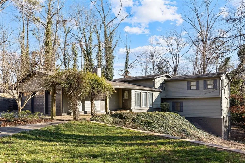 Tri-level home featuring a front yard, covered porch, and a chimney