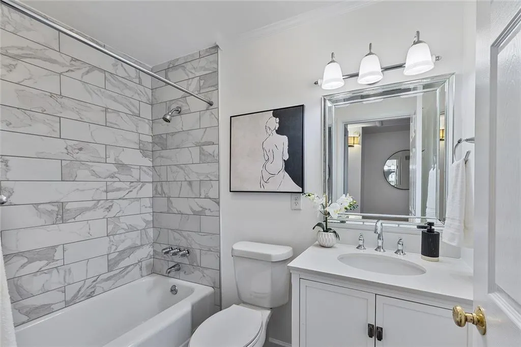 Full bath with shower / washtub combination, vanity, and ornamental molding