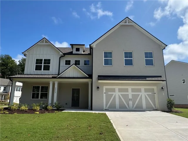 Painted brick exterior with board and batten accents, covered front porch, and a two-car garage