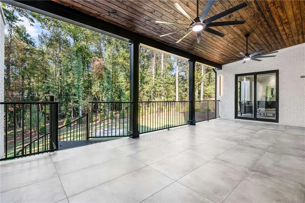Unfurnished sunroom with a ceiling fan and a patio area