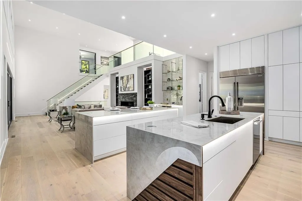 Kitchen featuring modern cabinets, a stone fireplace, white cabinetry, light wood-style flooring, and recessed lighting