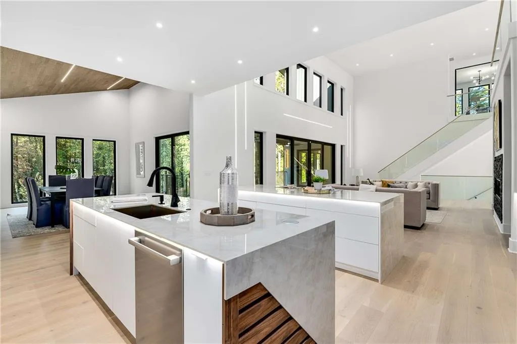 Kitchen with modern cabinets, white cabinets, a kitchen island with sink, a high ceiling, and healthy amount of natural light