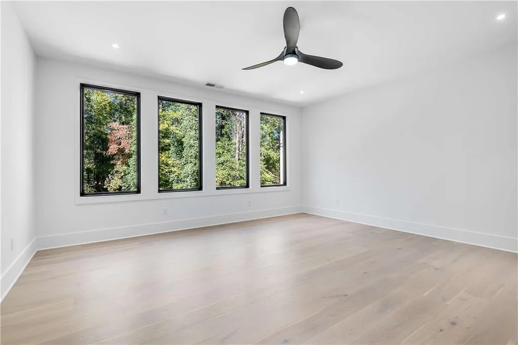 Empty room featuring light wood-type flooring, a ceiling fan, and recessed lighting