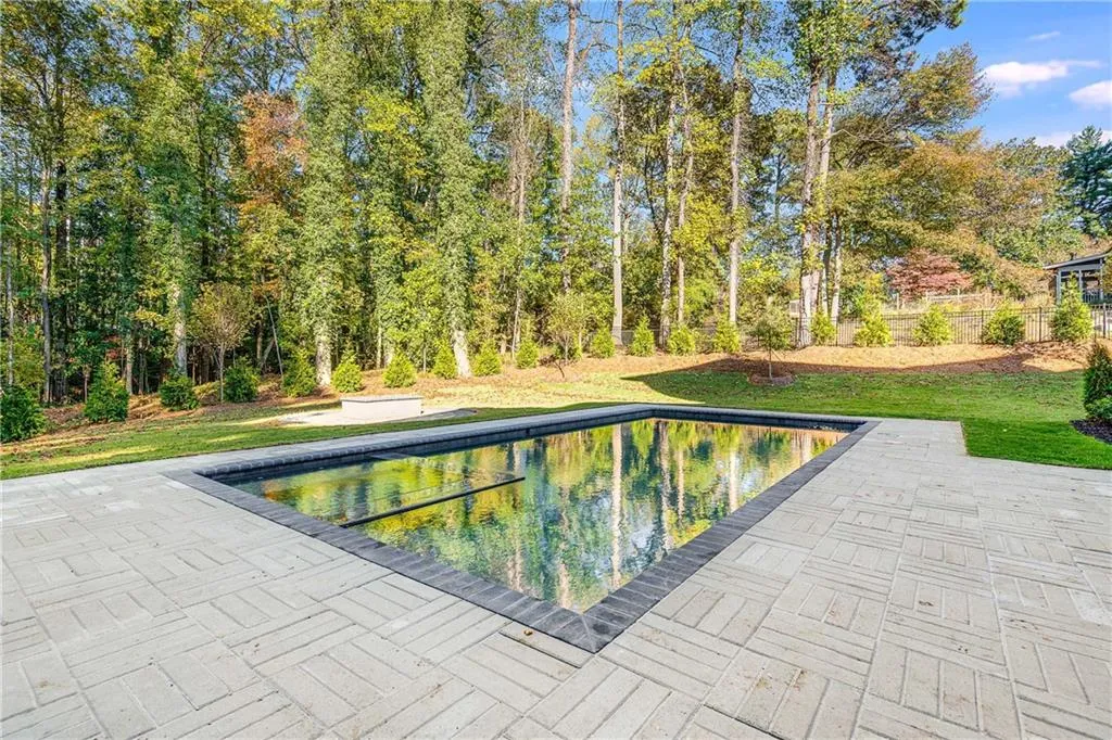 Swimming pool featuring a lawn and a patio area