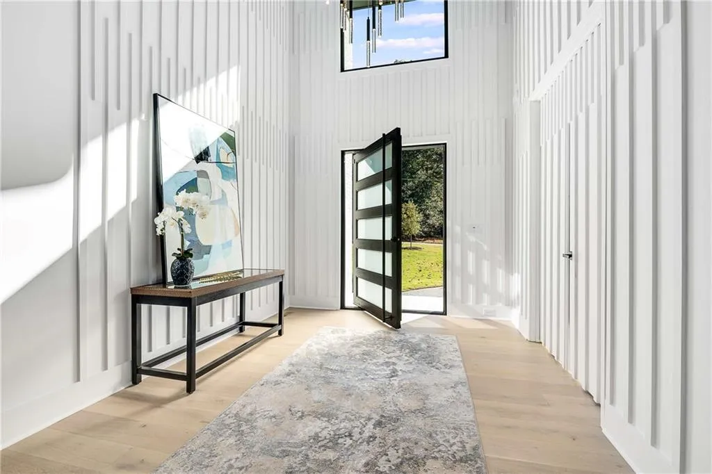 Entryway with light wood-type flooring and a high ceiling