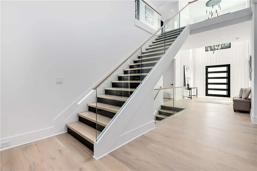 Stairway with wood finished floors and a towering ceiling