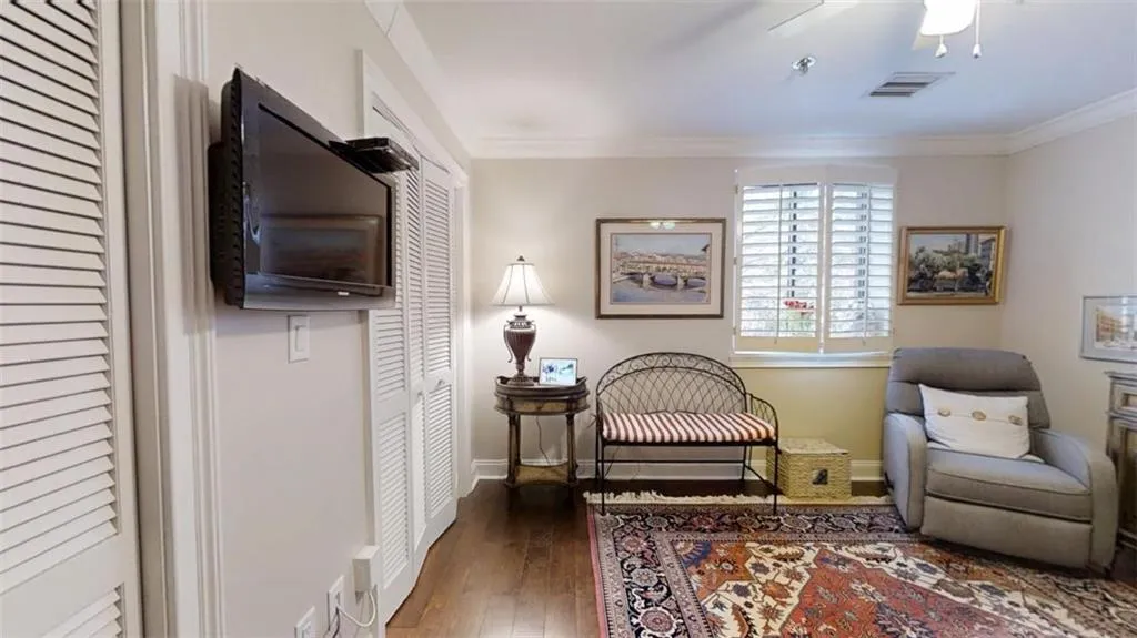 Sitting room featuring ornamental molding, wood finished floors, visible vents, and baseboards