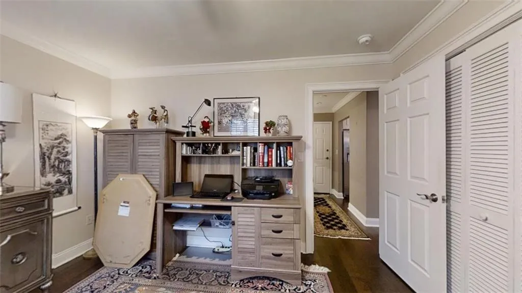 Office space with ornamental molding, baseboards, and dark wood-style floors