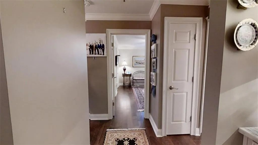 Hall with baseboards, ornamental molding, and dark wood finished floors