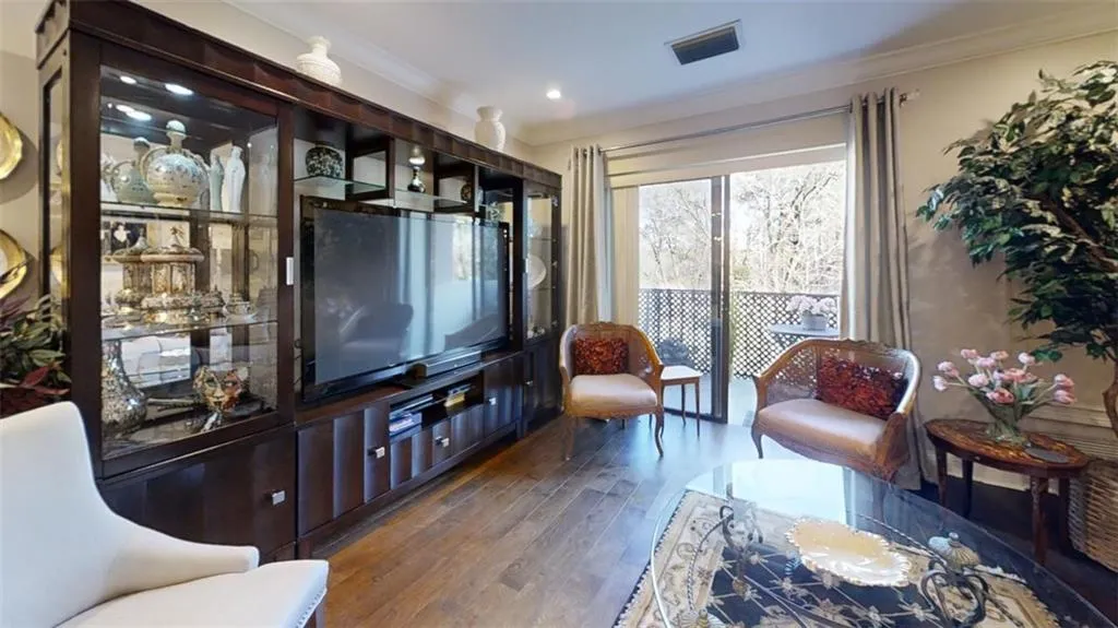 Living area featuring ornamental molding, wood finished floors, and visible vents