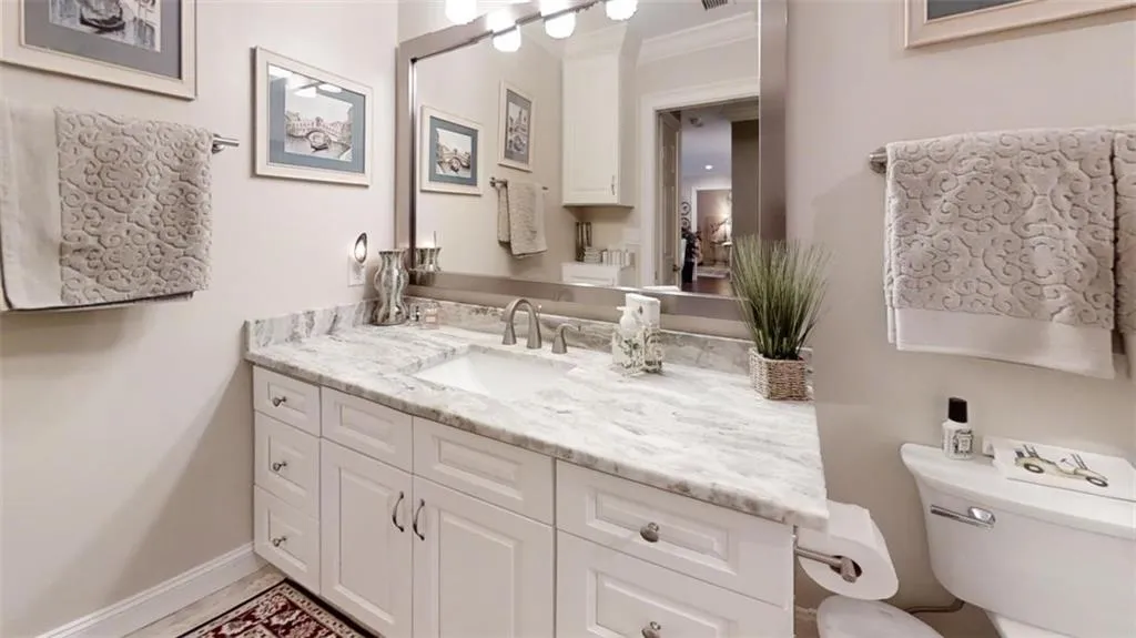 Bathroom featuring toilet, baseboards, ornamental molding, and vanity