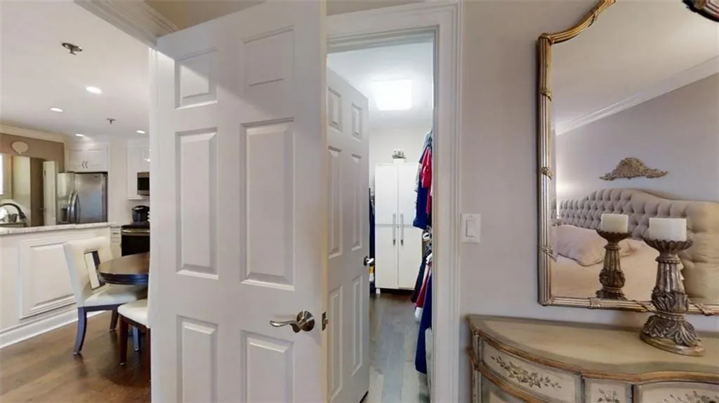 Corridor with dark wood finished floors, crown molding, and recessed lighting