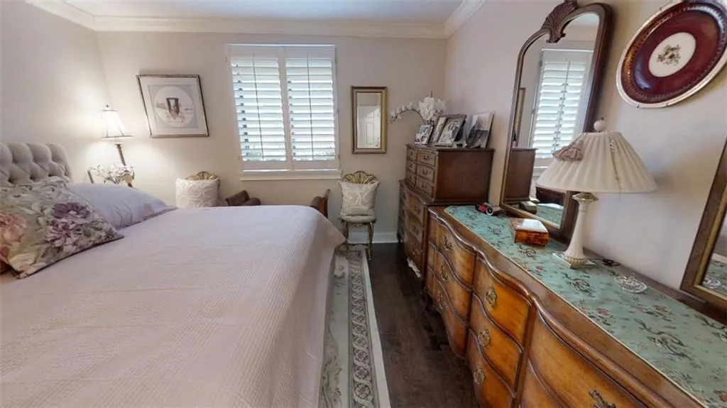 Bedroom with dark wood-style flooring, multiple windows, and crown molding