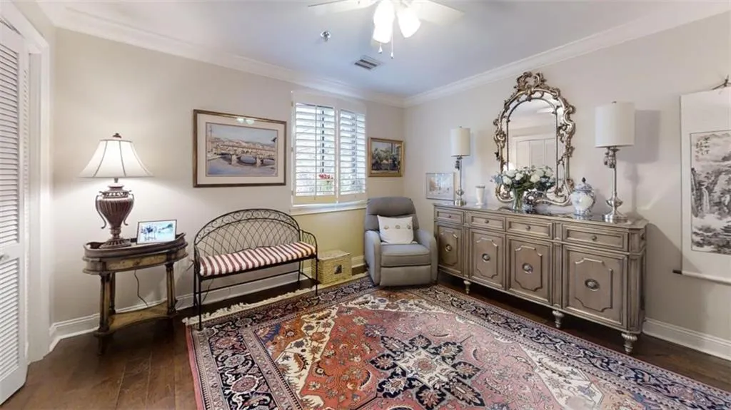 Sitting room featuring baseboards, visible vents, dark wood finished floors, ceiling fan, and ornamental molding