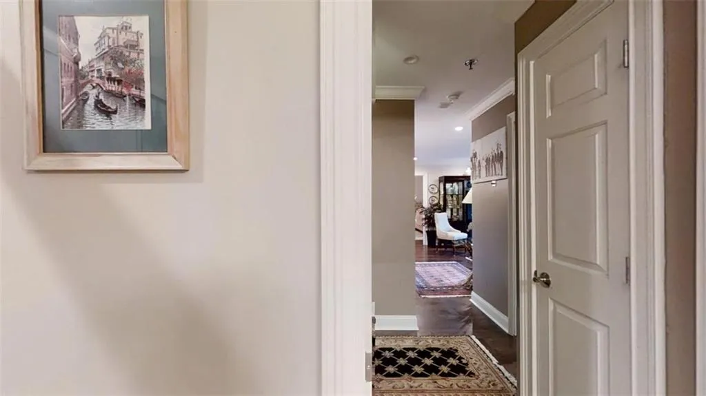 Corridor featuring dark wood finished floors, crown molding, baseboards, and recessed lighting