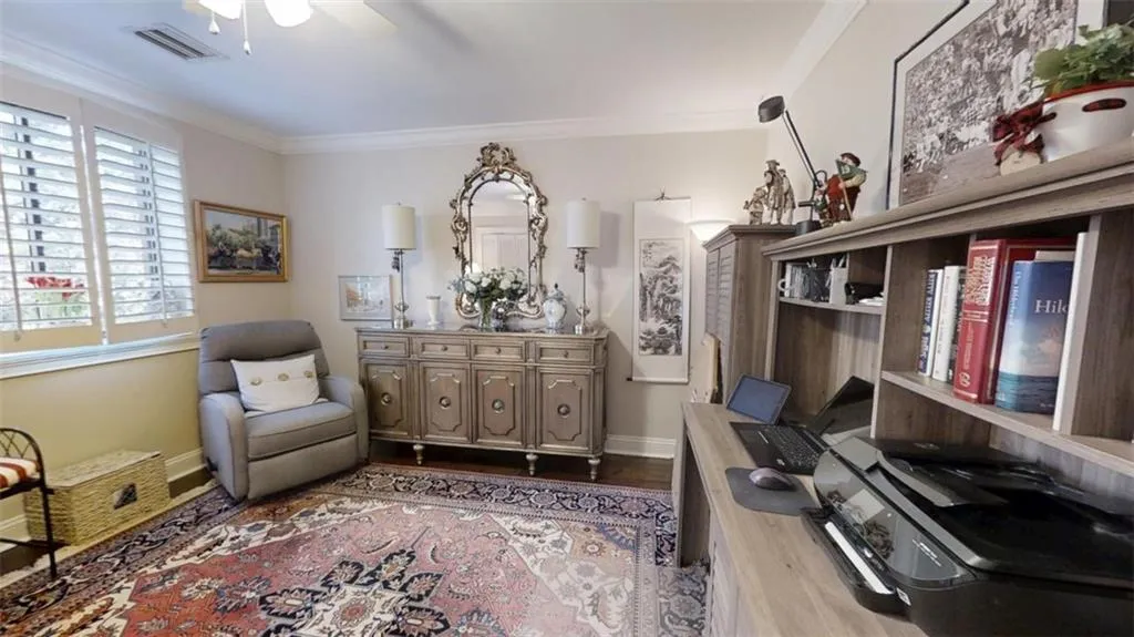 Sitting room with baseboards, visible vents, a ceiling fan, dark wood-style flooring, and crown molding